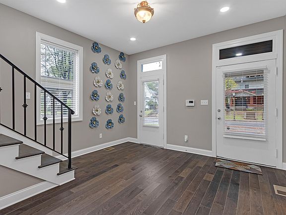 Inviting entry foyer with hardwood floors, staircase access, and sidelights for easy everyday comings and goings.