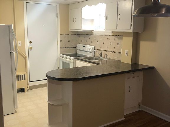 Kitchen & Dining Area. Door leads to laundry, storage unit & rear building entrance.