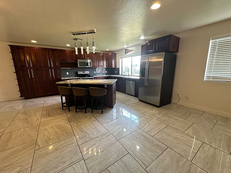 Large open concept kitchen with pendant lights and granite countertops