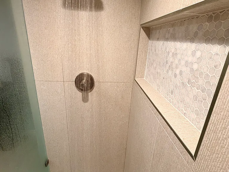 Primary bathroom shower. Kohler fixtures. Large cubby.