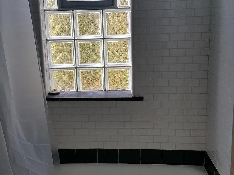 Renovated bathroom features a glass block wall (Private - no worries), New subway tile and shower surround, and fresh floor tile. The bathroom also features a vent and heater combo - to make it super warm. This is the only bathroom in the unit - but it's