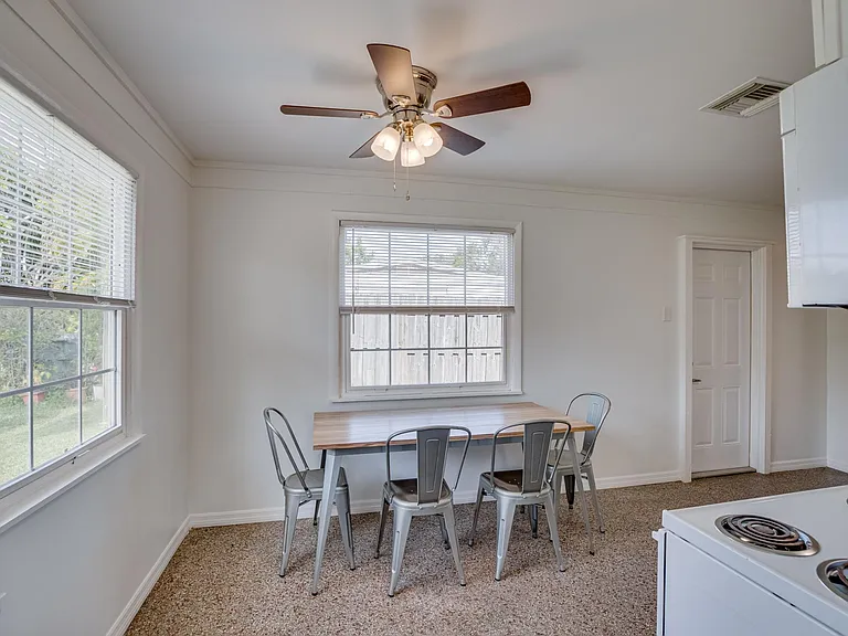 Large eat-in kitchen with granite counters, terrazzo floor, and ceiling fan. Access to 3/4 bath.