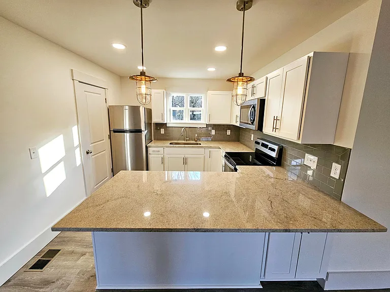 Large granite island with room for barstools. Ample storage on both sides of the island.