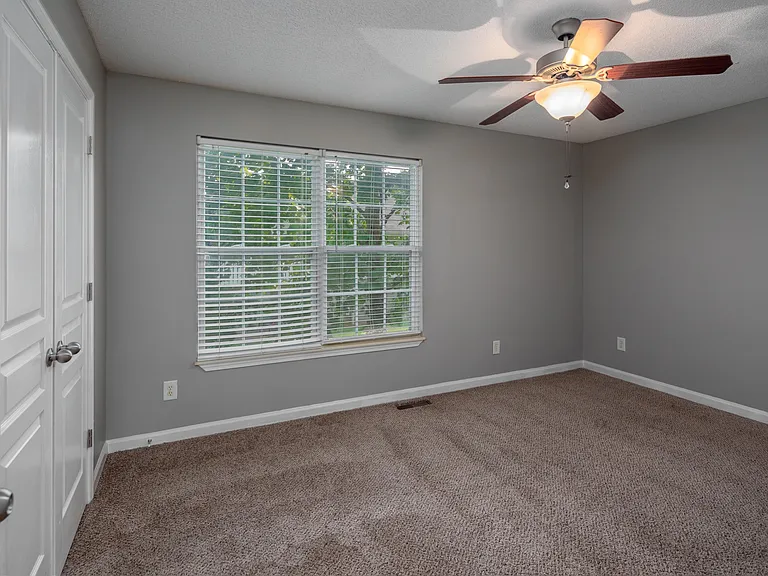 Cozy bedroom with carpet and overhead lighting