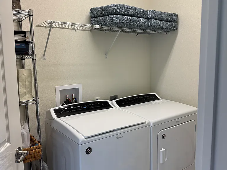 Laundry room with shelving for storage behind door. New cushions for ourdoor table on the lanai
