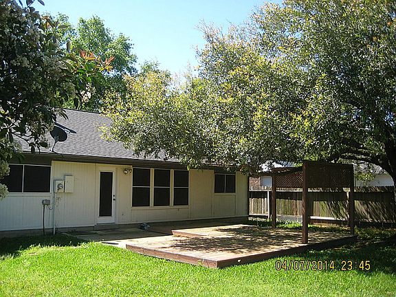 Backyard with beautiful oak tree and large deck.