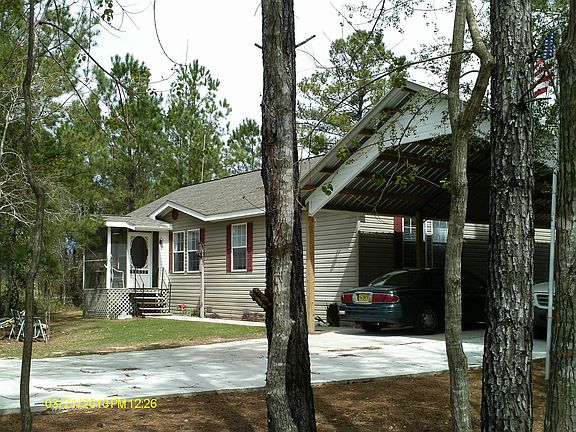 Front of house showing entrance to large carport