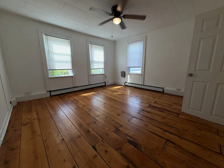 Bedroom #1 with ceiling fan and original floors