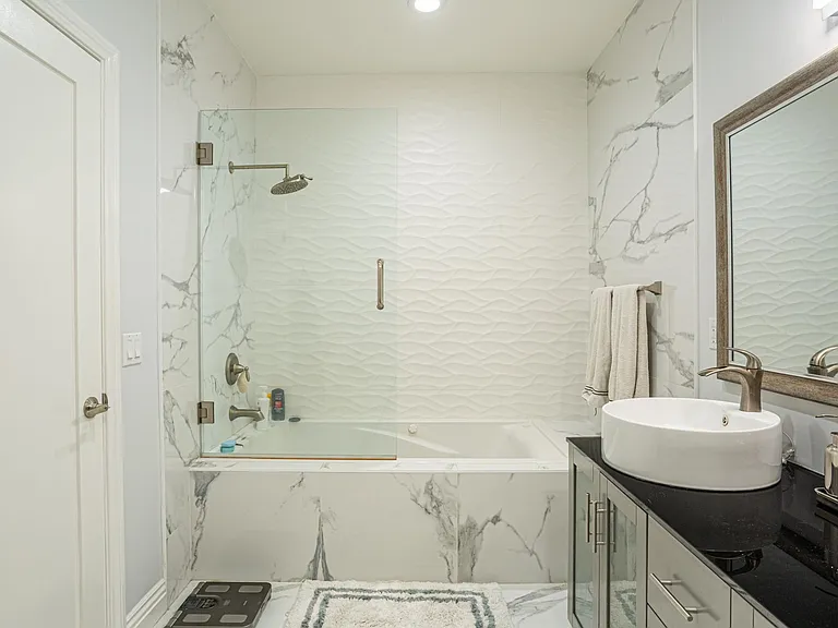 Primary suite bathroom with dual vessel sinks and jacuzzi tub