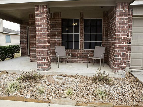 An inviting front porch with a soothing rock fountain in the flower bed will welcome you home every day.