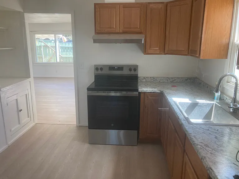 This is a view to the south into the huge Living room/dining room. The stove is electric. There are built in cabinets to the left of the door.There is room for a tablr or desk on the east wall, The electricity to the kitchen was fully updated