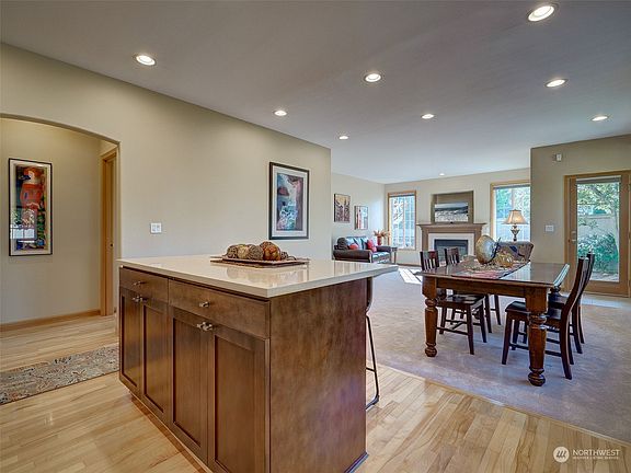 Beautifully maple cabinets and quartz counters in the kitchen. Owners' suite off to the left.>