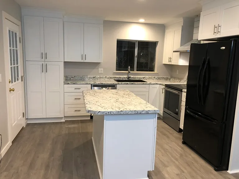 Kitchen with island, plenty of cabinets, pantry & back patio door.