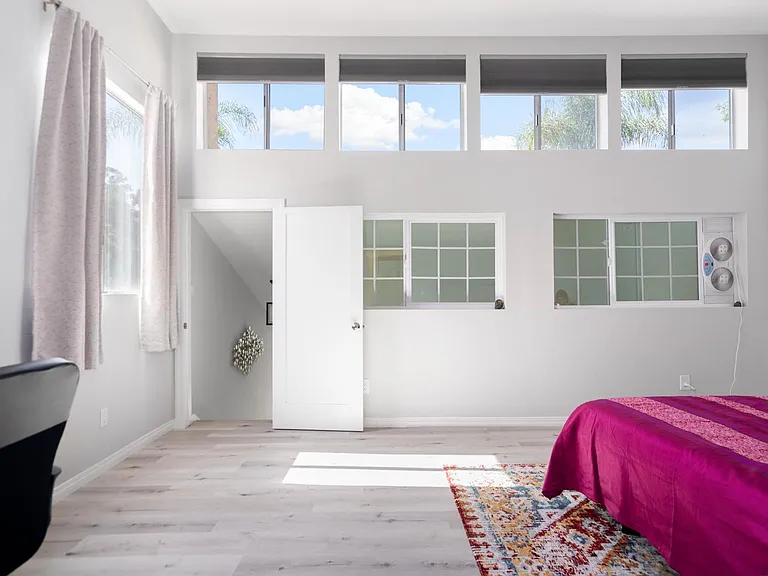 Master bedroom with vaulted ceilings brings in abundant light from 4 windows (comes with energy efficient / light blocking cellular shades)