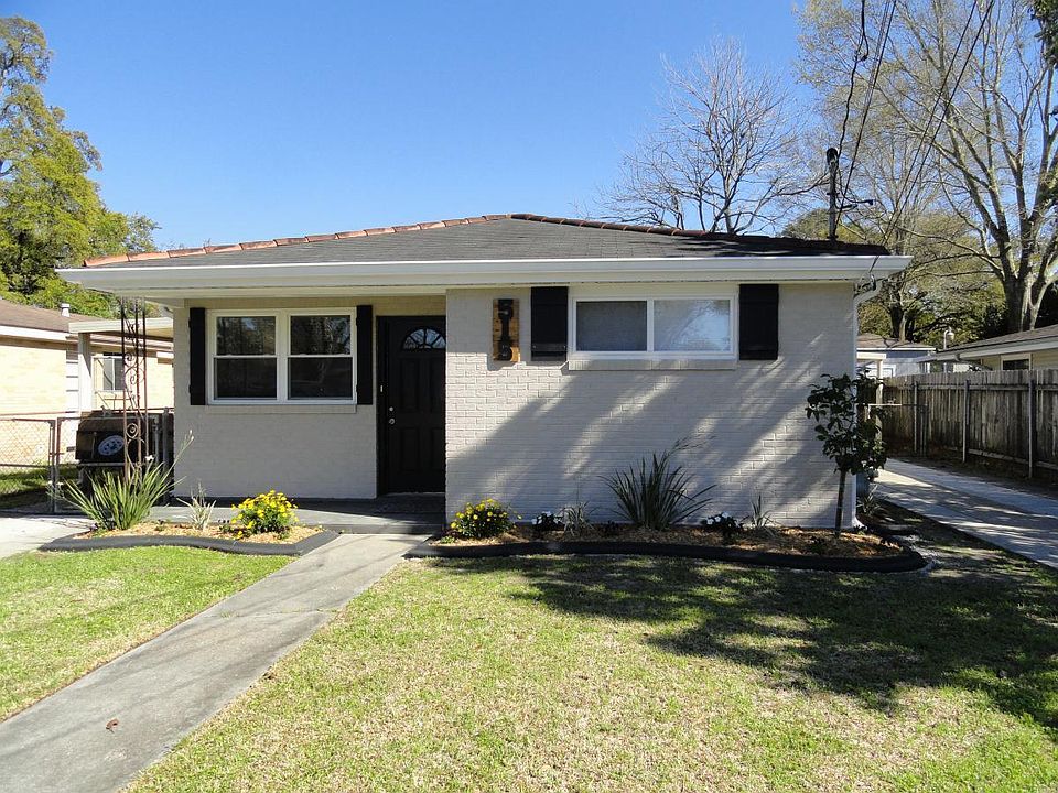 Front View, Driveway to left with covered Patio