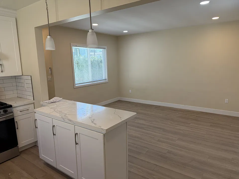 Kitchen peninsula and living room with all hardwood floors