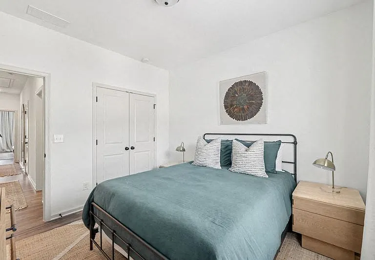 Secondary bedroom with queen size bed and large window letting in a ton of natural light.