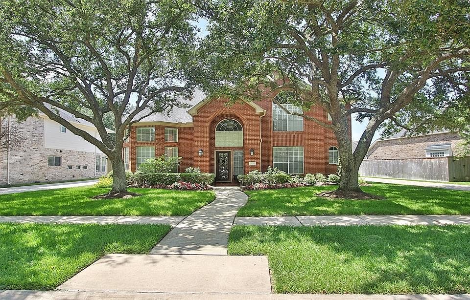 Mature trees and landscaping, as well as recently added colorful plants, frame this timeless and traditional elegant style home.