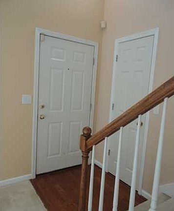 Foyer with raised ceiling and hardwood flooring
