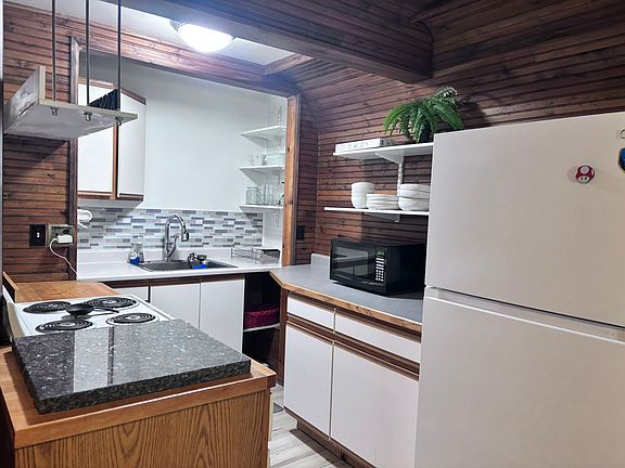 kitchen, includes a stove, refrigerator, and microwave