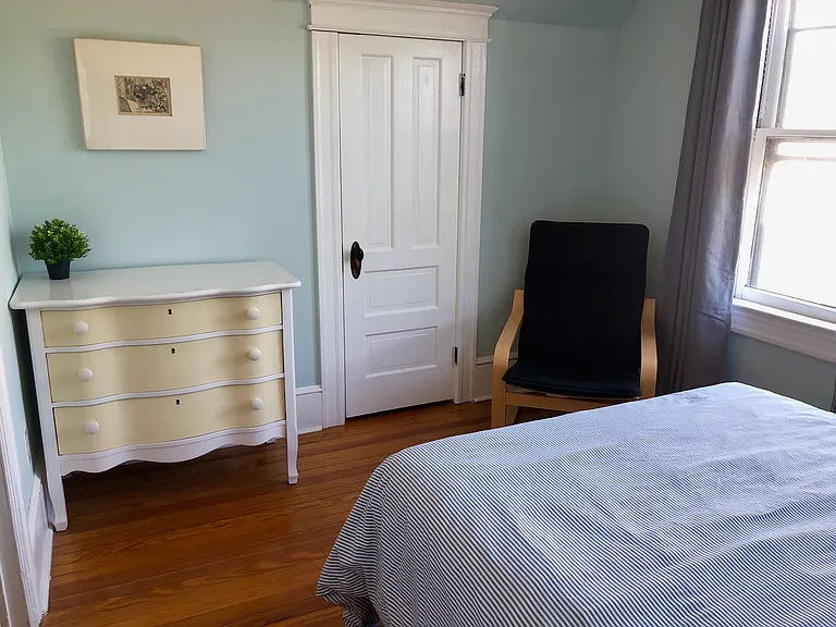 North facing back bedroom. Full size bed, 2 bedside tables, lovely vintage dresser, easy chair, ceiling fan, closet