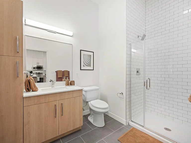 Designer bathrooms feature Shaker-style vanities and quartz countertops.