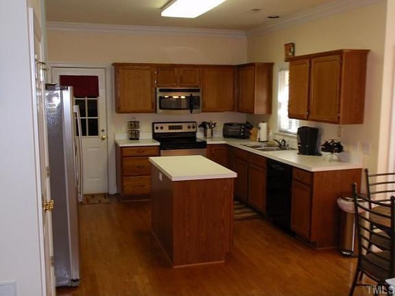  Efficient Kitchen with island and stainless refrigerator, stove and microwave