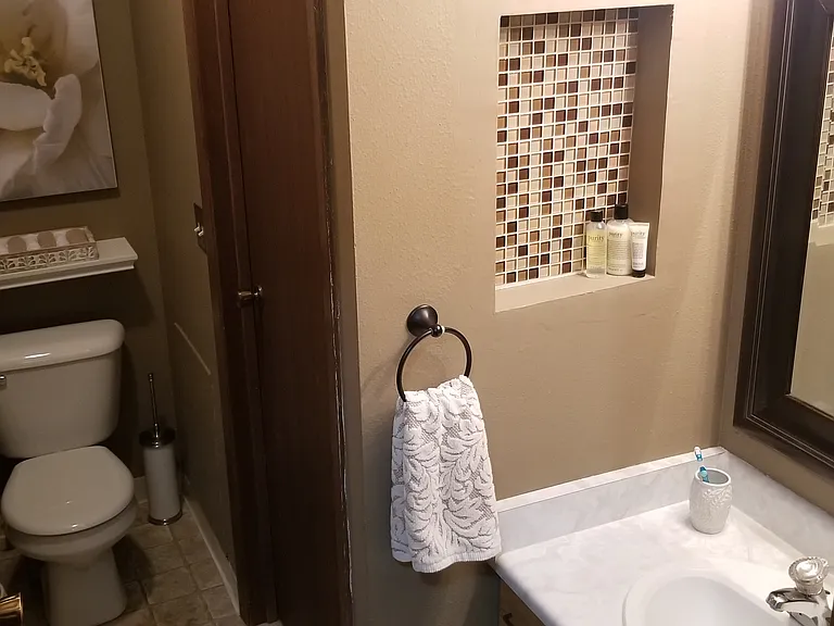 The Jack-and-Jill bathroom design has a toilet and a sink on each of its two end split sections connected by a third section where the bathtub/shower is. This is one of the end sections.