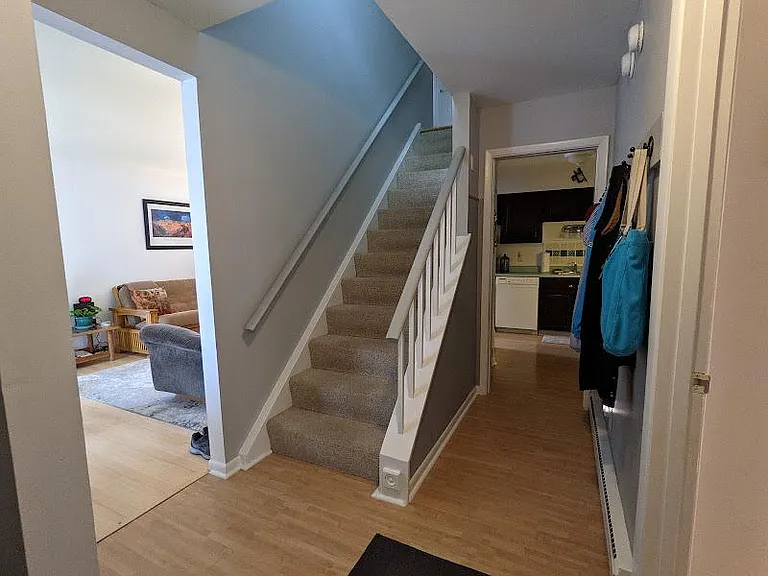 Stairs, living room, and kitchen seen from entrance