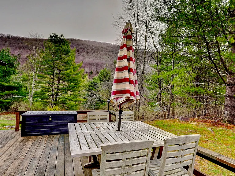 Springtime view of the open deck with patio furniture and storage bin.