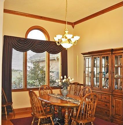 The dramatic dining room next to the foyer has 14 foot ceilings