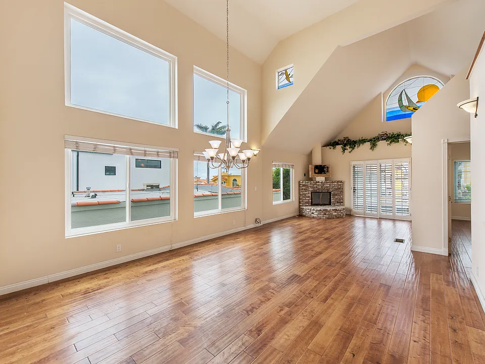Bright and spacious with huge wall of windows, hardwood floors, balcony and soaring ceilings