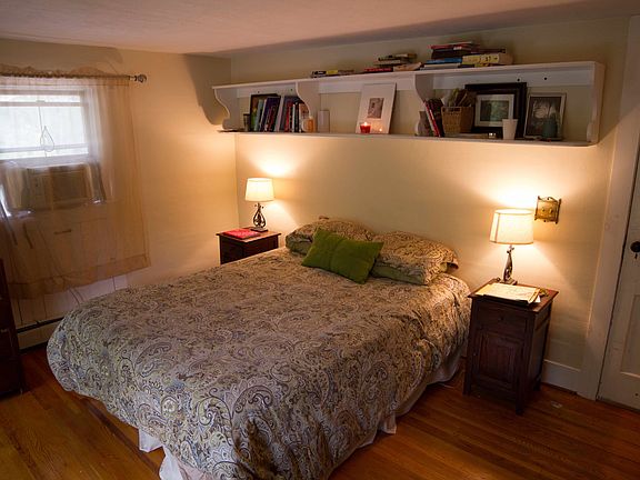 Upstairs bedroom with large closet, wood floors, tall window