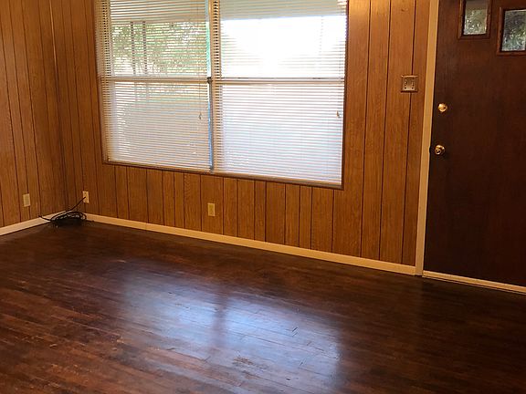 Living room with big windows overlooking front porch.