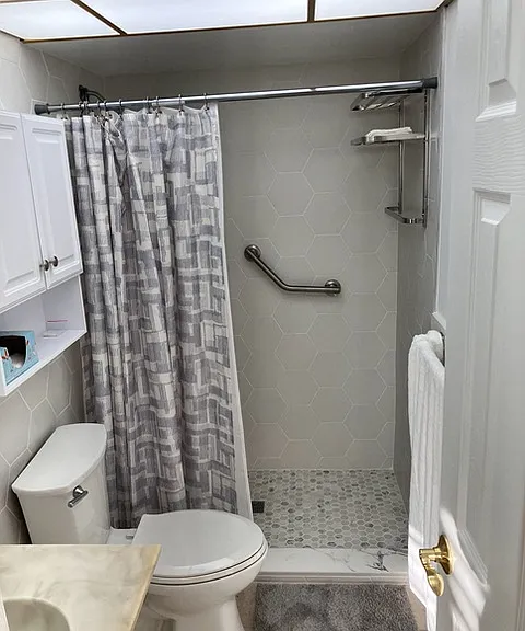 Newly renovated primary bathroom featuring a step-in shower with grab bar.