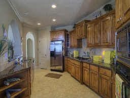 This unique kitchen features stainless steel appliances, granite countertops, beautiful tile backspl