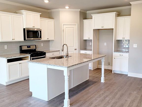 Kitchen with granite countertops, white cabinets and luxury vinyl floring
