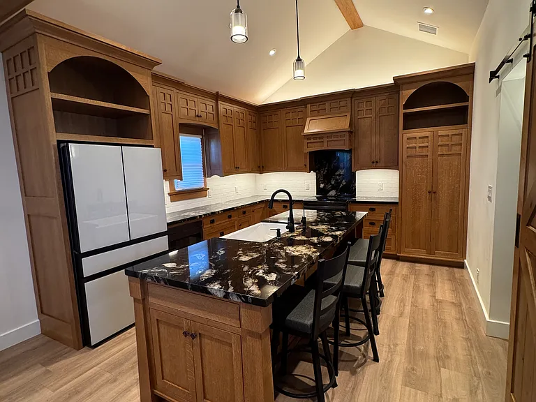 Island (stools included) with Samsung Bespoke French Door with Beverage Center Refrigerator with glass doors and Sharp drawer microwave oven under the counter.