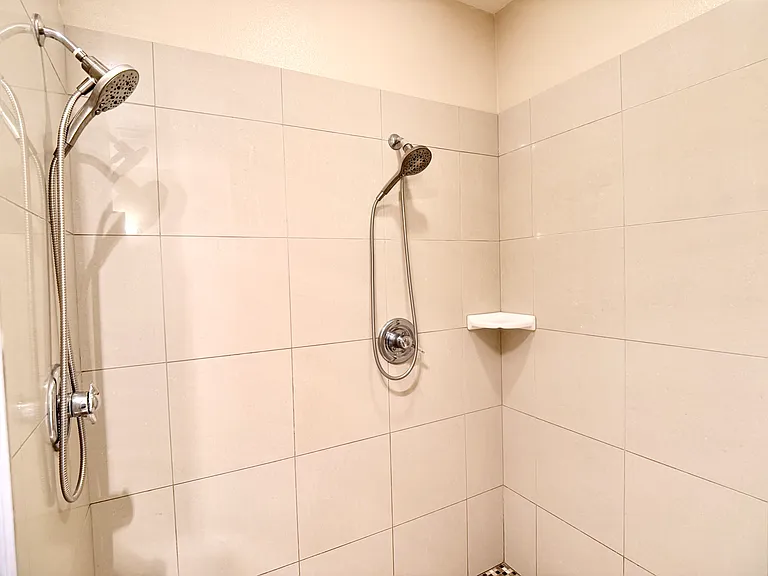 Luxurious walk-in shower appointed with dual rainfall showerheads for a spa-like experience.