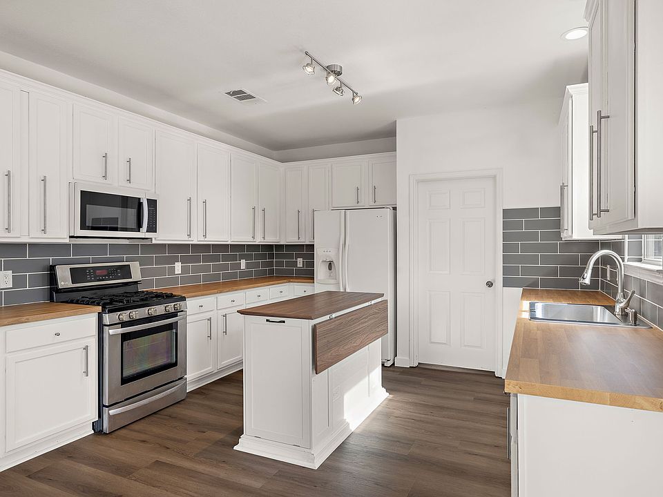 Chef's Kitchen: Island, Butcher Block Countertops, Modern Backsplash, Gas Cooktop, Modern Appliances, Walk-in Pantry.