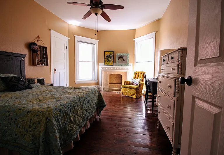 Bedroom 2 with decorative fireplace and large windows.