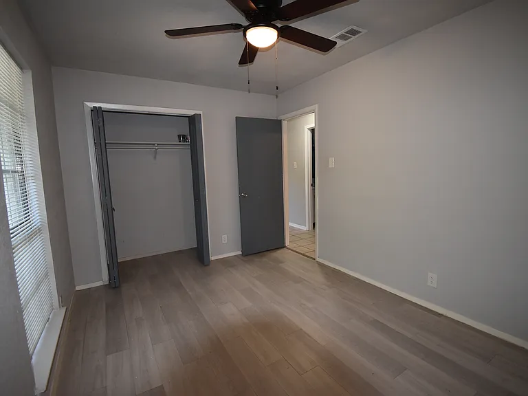 Primary bedroom features a new ceiling fan and a large window.