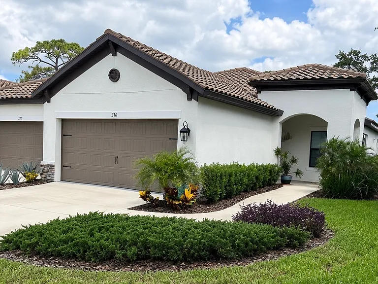 Corner lot front of the property with two car garage. Prior to palm trees