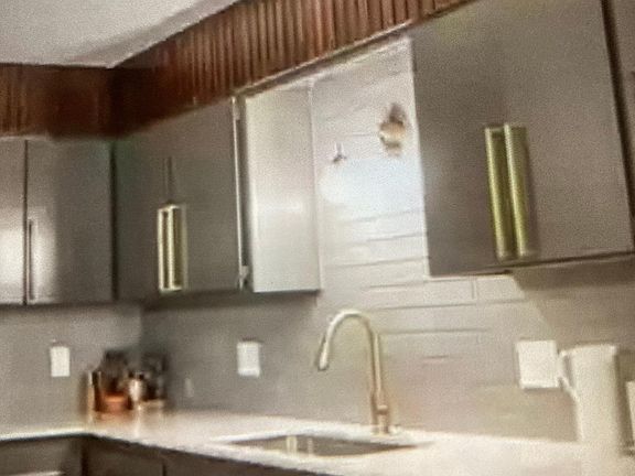 Modern freshly painted cabinets with gold hardware, newer stove, microwave and dishwasher.