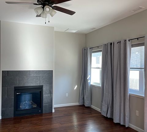 Living room with gas fireplace, ceiling fans in each room, hardwood floors