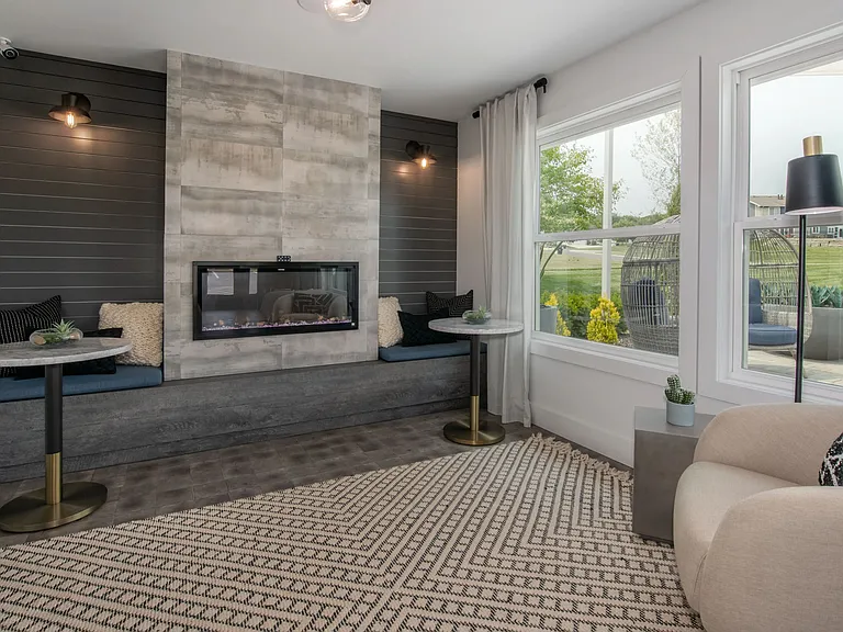 Cozy up by the fireplace in the WiFi Lounge, surrounded by elegant decor, abundant seating, and panoramic views of the outdoor lounge area and pool.
