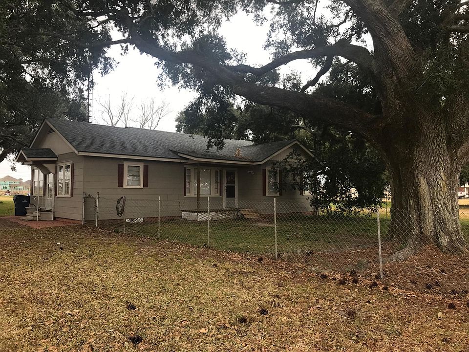 Front & driveway side view showing front porch & fenced in front yard