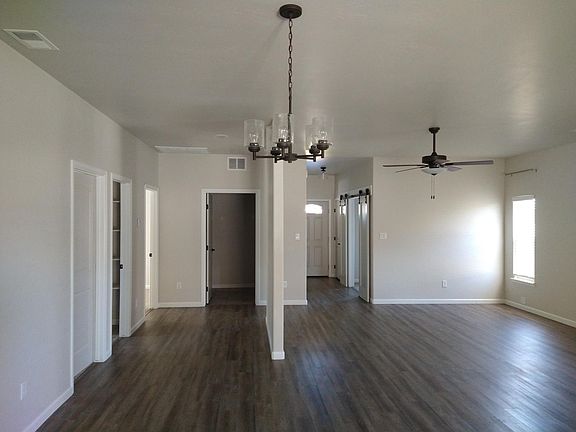Center is front door. To right of front door is office. Under ceiling fan is living room area. Straight ahead is laundry room door. Two bedrooms and bathroom along left wall.