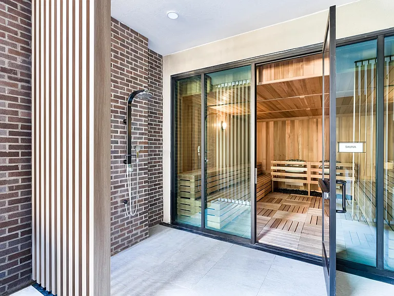 An on-site sauna with adjacent outdoor shower offers a refreshing wellness experience just steps from home.