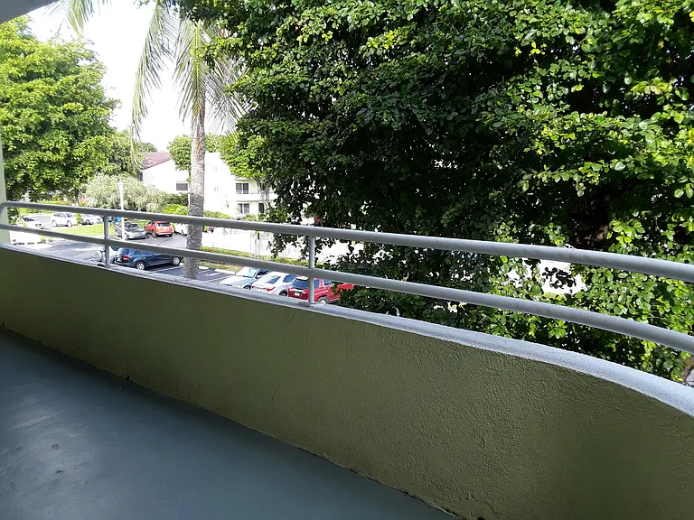 Balcony with view to the pool and parking area.